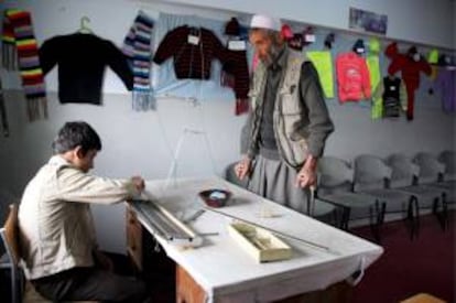 Un instructor afgano enseña a un niño huérfano a coser en un orfanato de Kabul (Afganistán). Varias ONG trabajan para ayudar a los más necesitados en países pobres. EFE/Archivo