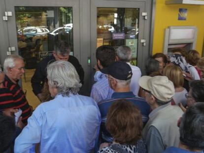 Pensionistas hac&iacute;an cola el jueves para retirar dinero a la entrada de una sucursal bancaria en Sal&oacute;nica, Grecia. /EFE