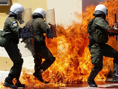 Varios policías tratan de un huir de un cóctel molotov en una manifestación en Atenas