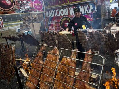 Un chef alimenta el fuego para asar en la feria gastron&oacute;mica Mistura, en Lima.