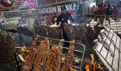 Un chef alimenta el fuego para asar en la feria gastron&oacute;mica Mistura, en Lima.