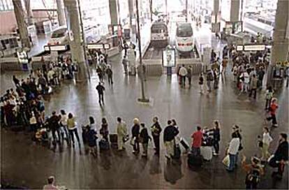 Decenas de pasajeros esperaban ayer en la estación del AVE, en Atocha, para dirigirse a Sevilla.
