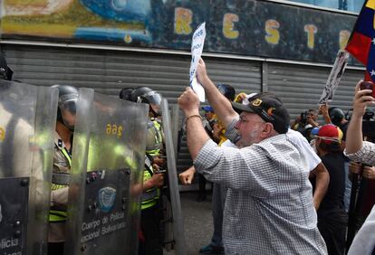 Un manifestante de la oposición confronta a los agentes de la policía antidisturbios, en Caracas. 