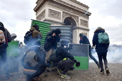 Según cifras comunicadas por el ministerio del Interior francés, unos 7.000 a 8.000 personas se manifestaban el sábado en la capital francesa, entre ellos 1.500 ultraviolentos. En la imagen, un grupo de manifestantes junto a una barricada cerca del Arco del Triunfo en París (Francia).