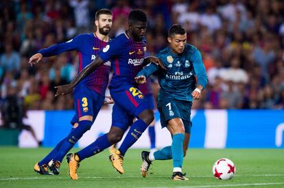 Cristiano lucha con Umtiti y Piqué, durante la Supercopa.