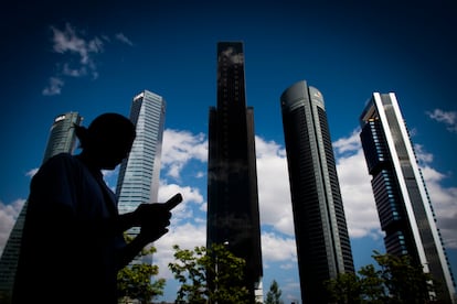 Una mujer pasa por debajo de la zona de las Cuatro Torres, en Madrid.