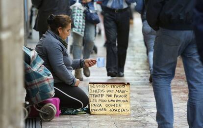 Una mujer pide en las calles de Valencia. 