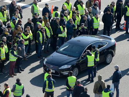 Un grupo de taxistas rodea a un coche de Cabify en Barcelona.