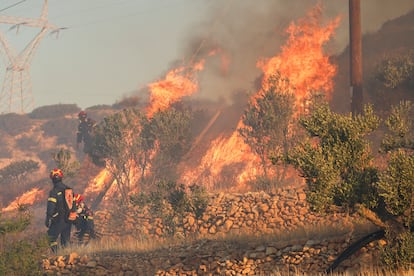 Los bomberos observan las llamas crecientes mientras un incendio forestal arde cerca de Ierapetra, este jueves en Creta.