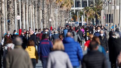 Traseuntes por el paseo marítimo de Barcelona, este sábado.