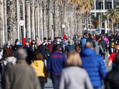 Traseuntes por el paseo marítimo de Barcelona, este sábado.