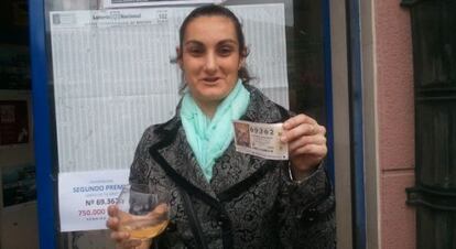 Nerea Santisteban, con el décimo premiado en la mano ante la administración de lotería de Barakaldo donde lo compró.