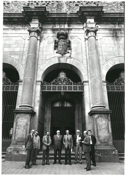 Algunes de les ànimes de l’Assemblea de Catalunya (a sota, el carnet de la plataforma) davant l’església de Sant Agustí el 1981, als 10 anys dels fets: Josep Benet, mossèn Joan Carrera, Antoni Gutiérrez Díaz, Agustí de Semir, Pere Portabella, mossèn Josep Maria Vidal Aunós, Miquel Sellarès i Jordi Carbonell. L’assassinat del treballador de Seat Antoni Ruiz Villalba va enterbolir aquells dies.