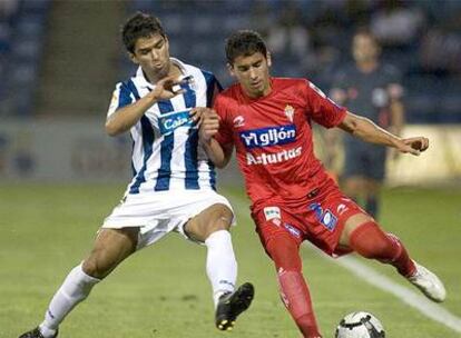 Candeias luchando con Botía, defensa del Sporting, por el balón.