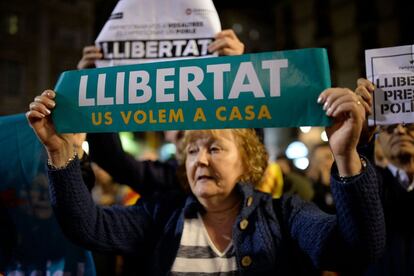 Una mujer sujeta una pancarta que dice 'Libertad. Os queremos en casa' durante la manifestación frente al Ayuntamiento de Barcelona. 