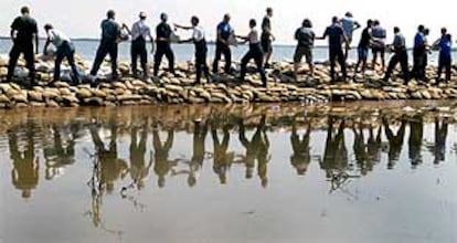 Decenas de voluntarios construyen un dique con sacos terreros a orillas del río Mulde para proteger la ciudad alemana de Bitterfeld (al este del país).