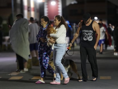 Un grupo de personas permanece en las calles después de registrarse un terremoto la madrugada del jueves en Ciudad de México.