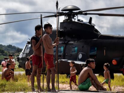 Un grupo de indígenas yanomami alrededor de un helicóptero de la Fuerza Aérea brasileña en el municipio de Alto Alegre, Estado de Roraima (Brasil).