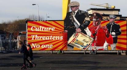En la imagen, niños caminan frente a un mural lealista de la zona este de Belfast.