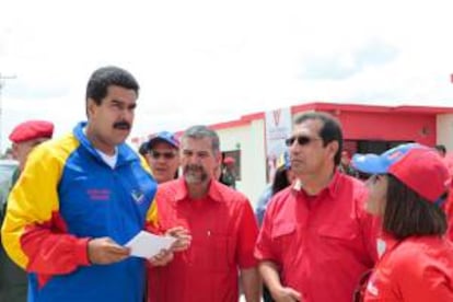 Fotografía cedida por el Palacio de Miraflores donde aparece el presidente Nicolás Maduro con su ministro de Vivienda, Ricardo Molina (2-i), y el gobernador de Barinas, Adan Chávez (2-d), este jueves 16 de mayo de 2013, durante el acto de entrega de 75 viviendas en Barinas (Venezuela).