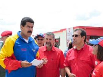 Fotografía cedida por el Palacio de Miraflores donde aparece el presidente Nicolás Maduro con su ministro de Vivienda, Ricardo Molina (2-i), y el gobernador de Barinas, Adan Chávez (2-d), este jueves 16 de mayo de 2013, durante el acto de entrega de 75 viviendas en Barinas (Venezuela).