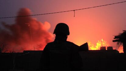 Un soldado afgano observa el incendio provocado por los militantes talibanes y que consume un almacén de combustible en Marjah