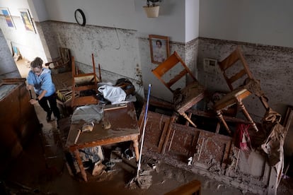 Una mujer limpia el interior de su vivienda afectada por las inundaciones en Valencia, este jueves.  