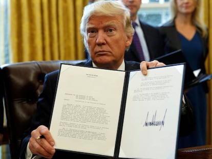 Donald Trump muestra su firma sobre una orden ejecutiva. 