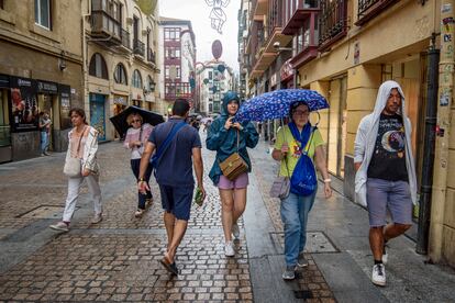 Varias personas se protegen de la lluvia en Bilbao, este viernes.