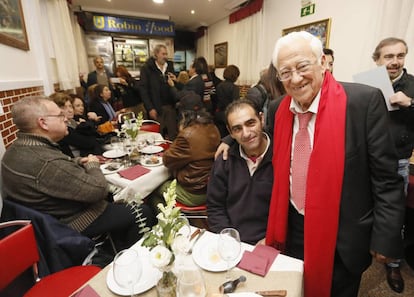 El padre Ángel con varias personas en su restaurante.