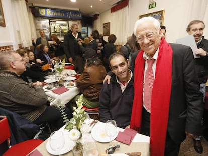 El padre Ángel con varias personas en su restaurante.