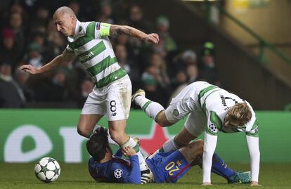 Scott Brown (izquierda) del Celtic se hace con el balón ante Sergio Roberto (tumbado) del FC Barcelona y Stuart Armstrong (derecha) del Celtic.