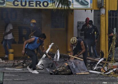 Um homem é socorrido após confrontos com a polícia durante a greve nacional contra a reforma tributária em Cali.