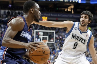 Ricky Rubio, al fondo, defiende ante Kemba Walker.