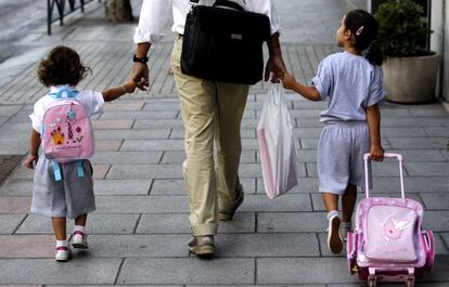 Un pare porta les seves filles a l'escola a Madrid.