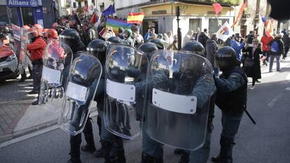 La plaza estaba blindada por agentes antidisturbios de la Policía Foral de Navarra y de la Guardia Civil desde las nueve de la mañana. En la imagen, varios efectivos de las fuerzas de seguridad vigilan las calles y mantienen separados los dos grupos de manifestantes: los que homenajeaban a la instituto armado y los que protestaban contra este acto.