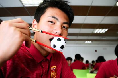 Li Hao, el portero del sub-15 chino, juega con un pequeño balón a la hora del almuerzo.