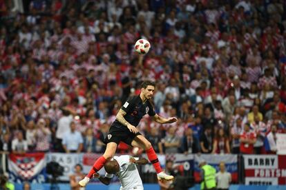 El defensa croata Sime Vrsaljko salta por encima del defensa inglés Ashley Young durante la semifinal, el 11 de julio de 2018.