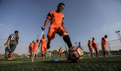 Um dos jogadores de futebol de "As muletas" controla a bola, durante uma sessão de treinamento.