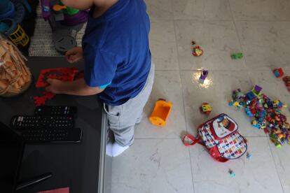 Lian juega con varios muñecos en el salón de su casa en Móstoles. 