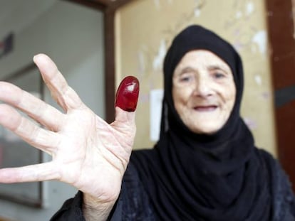 Egípcia exibe polegar marcado com tinta após votar.