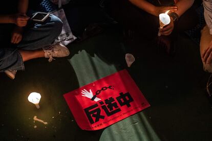 Este año, la participación en la vigilia se ha visto reforzada ante el rechazo al proyecto de ley de extradición, que de aprobarse permitiría que el jefe del ejecutivo y los tribunales locales tramitaran las solicitudes de extradición sin supervisión legislativa. En la foto, un cartel protesta contra el proyecto de ley de extradición se ve sobre el suelo durante los actos de conmemoración de las víctimas de Tiananmen, en el parque Victoria de Hong Kong.