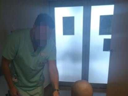 Un sanitario da la mano al niño en el Hospital Universitario de Torrevieja.