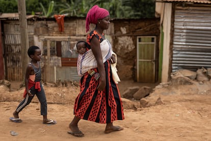 Una mujer carga con su bebé en la espalda en el exterior del mercado de Mulindi, en Kigali. En la capital de Ruanda viven hoy 1,2 millones de personas, pero el Gobierno cree que superarán los 3,5 millones en 2050.