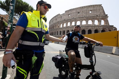 Un miembro de Protección Civil ofrece agua a un ciclista en Roma, este miércoles. 
