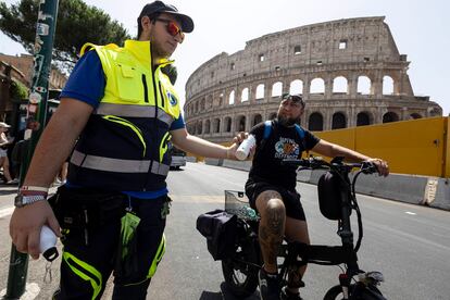 Un miembro de Protección Civil ofrece agua a un ciclista en Roma, este miércoles. 
