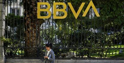 Una mujer junto a uno de los edificios de BBVA en Madrid.