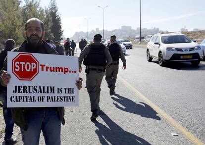 Un manifestante palestino sujeta una pancarta durante una protesta contra la construcción de asentamientos judíos en la Cisjordania ocupada y en contra del presidente electo Donald Trump, cerca del asentamiento Maale Adumim, al este de Jerusalén (Israel).