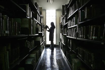Una trabajadora de la Biblioteca Nacional de Perú (BNP) busca un volumen entre los anaqueles de libros.