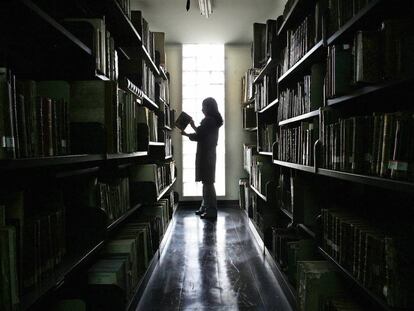 Una trabajadora de la Biblioteca Nacional de Perú (BNP) busca un volumen entre los anaqueles de libros.